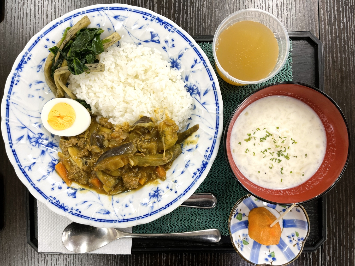 11月８日のメニューの写真です。トレーの上に、牛ひき肉のキーマカレー、大根のミルクスープ、マコモダケとほうれん草のソテー、長後の柿、が載せられています。